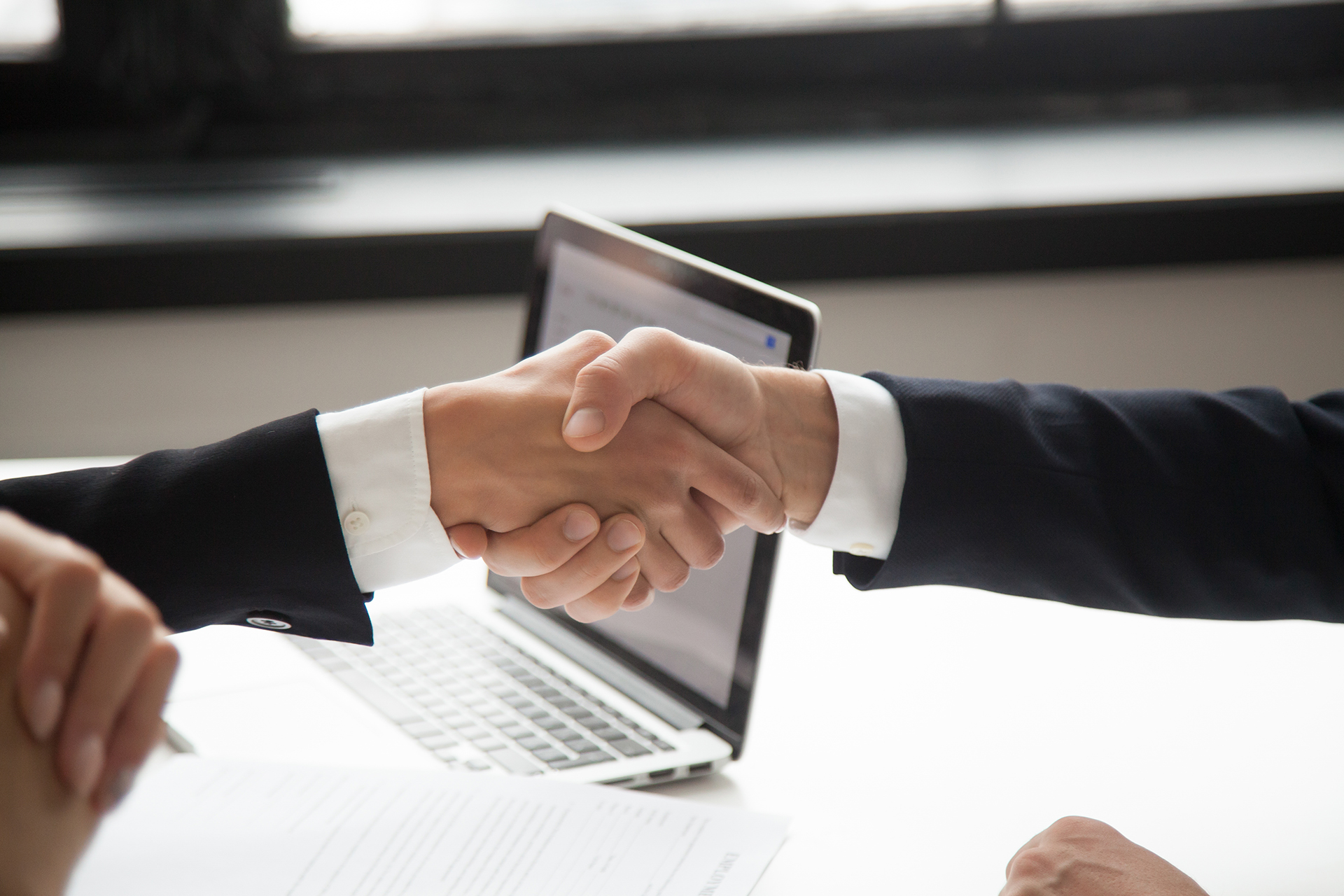 Businessman handshaking businesswoman as concept of good business deal and respect for new partner, successful partnership and great teamwork, hiring, close up view of male female hands shaking
